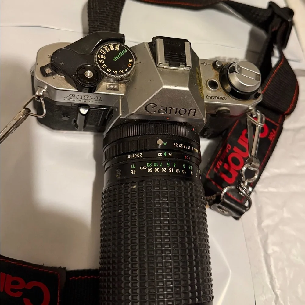 Canon silver and black SLR camera with black telephoto lens